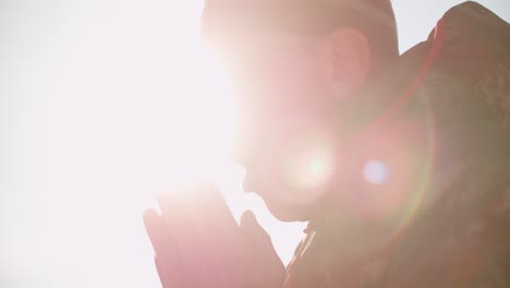 a person in a warm winter jacket warms hands, steams from his mouth setting sun over snowy landscape