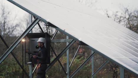 general plan of a male electrician conducting a technical inspection of a panel solar power plant