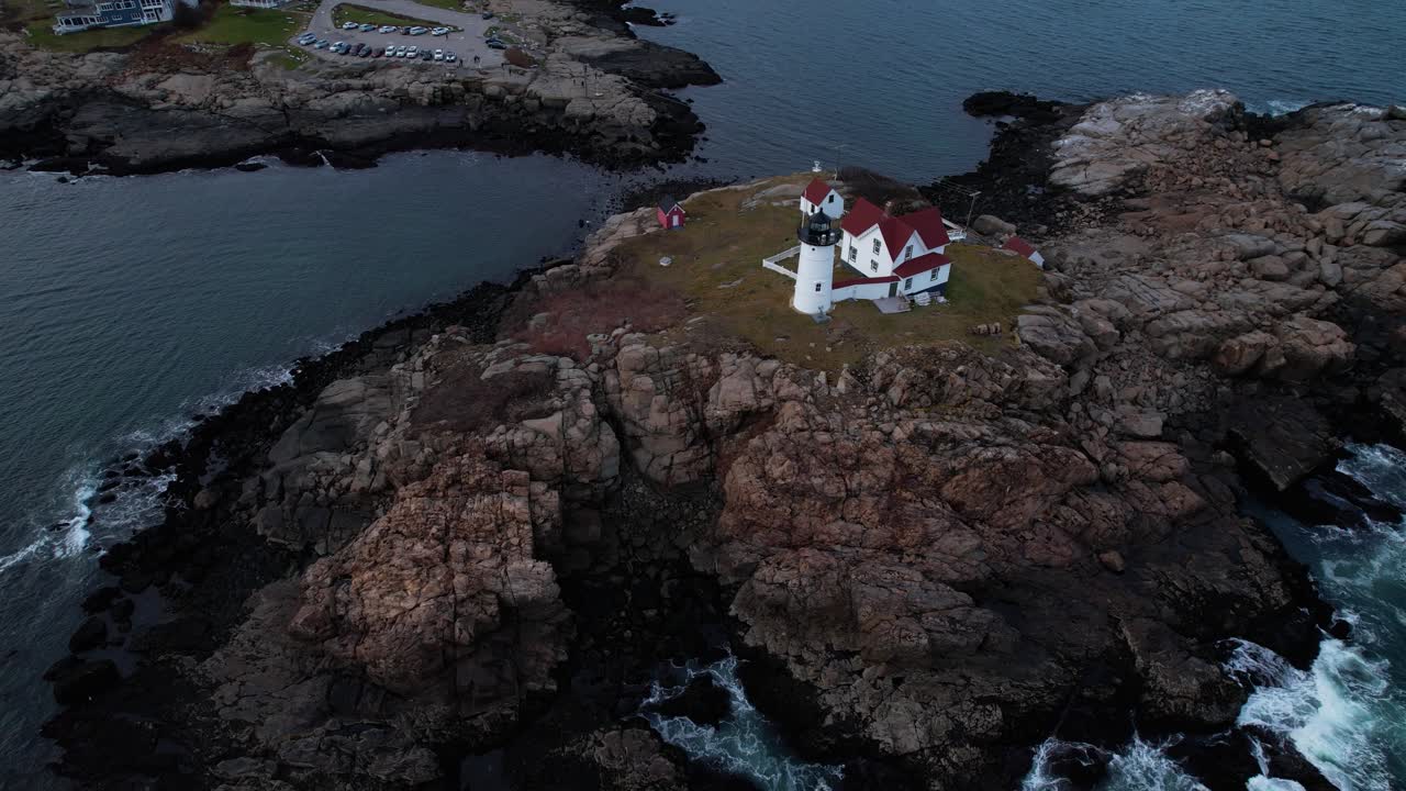 Tilting rotation above a lighthouse on a rocky Island off the coast of southern Maine with tides crashing on the rocks