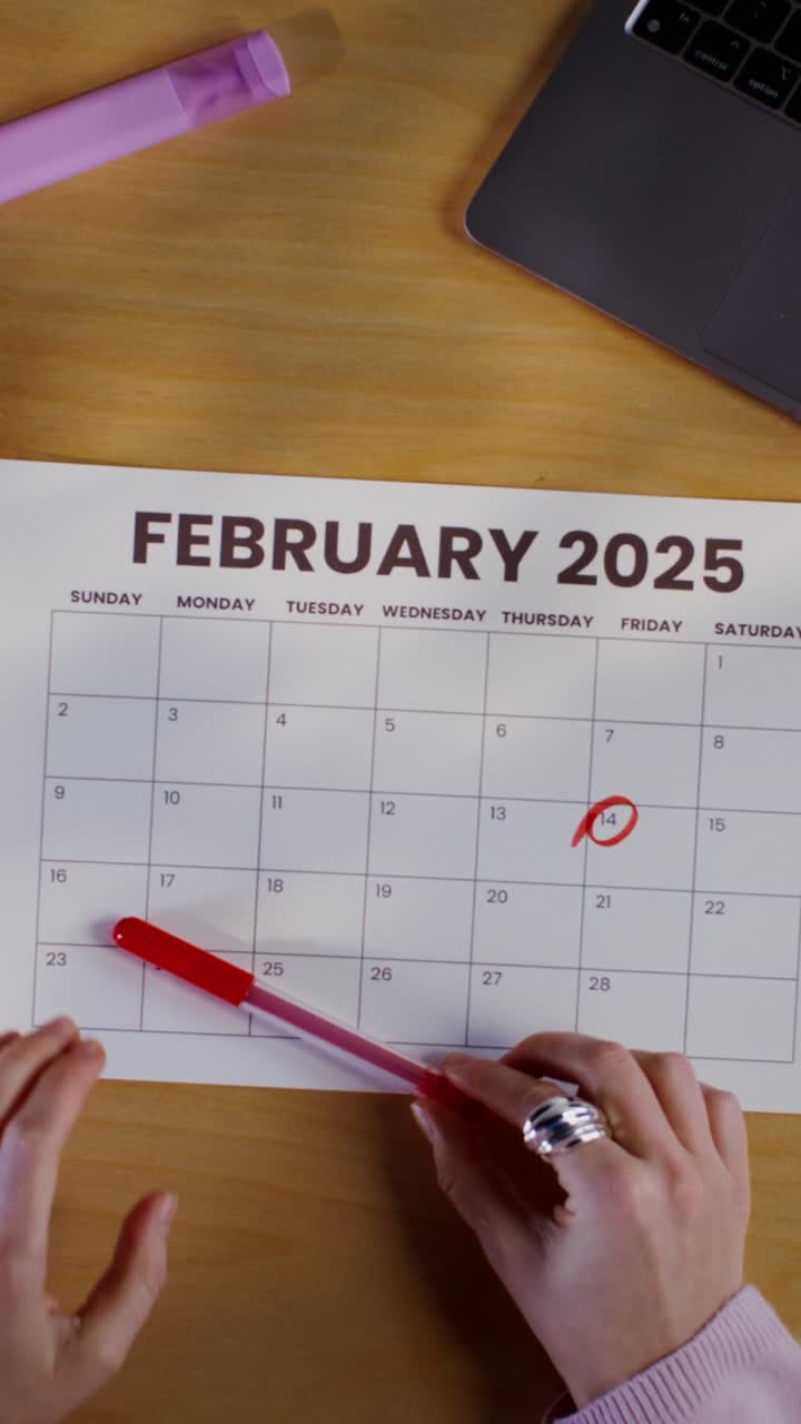 Woman Marking Date on February 2025 Calendar