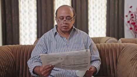 Indian-old-fat-man-reading-newspaper