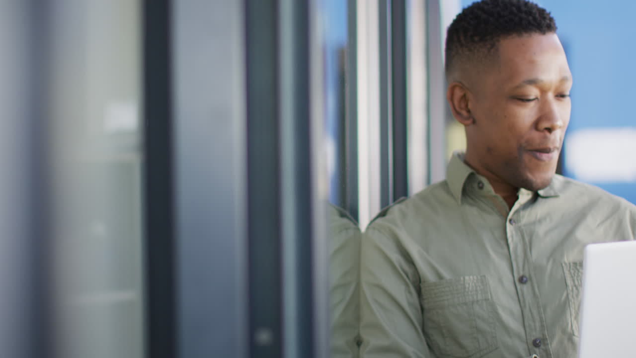 Portrait of african american businessman using laptop at office, copy space, slow motion