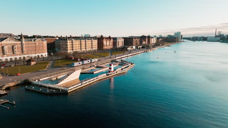 panorama moving drone shot of the downtown skyline of copenhagen in denmark of the river tryggevælde by sunset