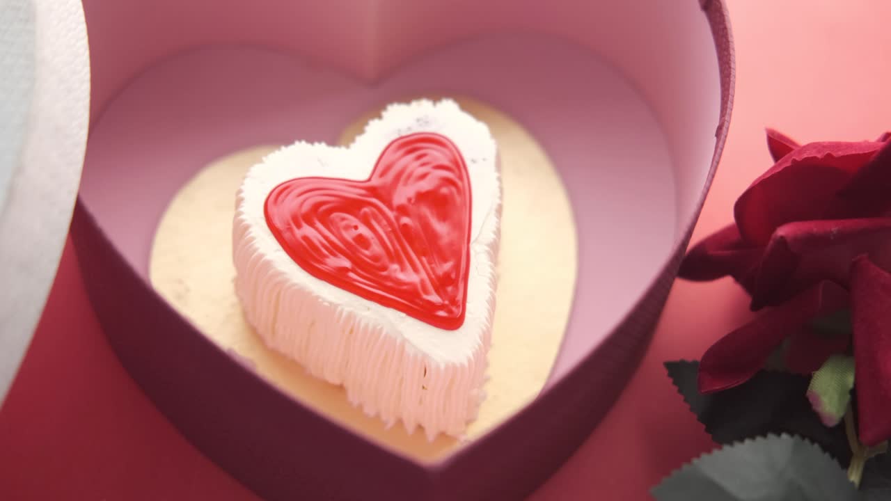 은 장미와 함께 분홍색 상자에 심장 모양의 케이크