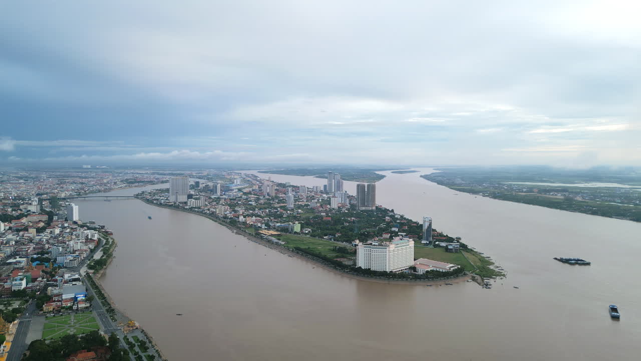 Aerial view of the Tonlé Sap and Mekong rivers converging in Phnom Penh, with high-rise buildings and hotels along the riverbanks