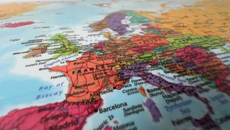 close-up of world map poster showing europe with france, germany, and italy highlighted on wall