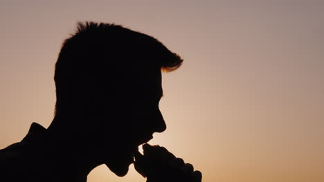 Side-View-Portrait-Of-A-Man-Who-Eats-A-Hamburger