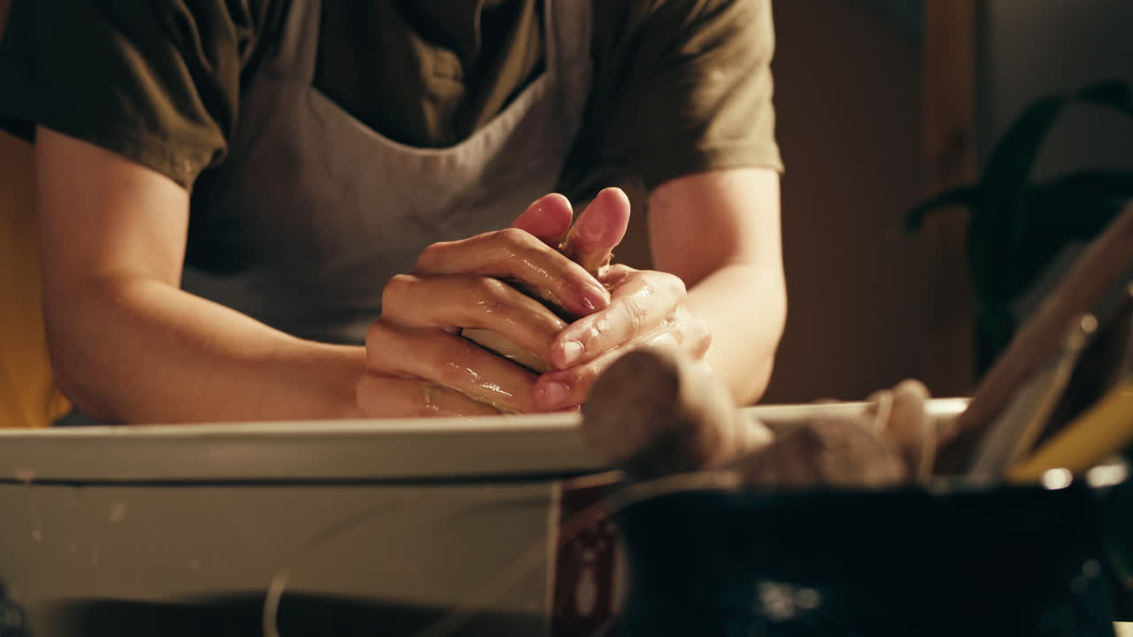 manos moldeando arcilla en una rueda de cerámica