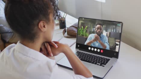 Afroamerikanische-Frau-Nutzt-Laptop-Für-Videoanrufe,-Mit-Geschäftskollegen-Auf-Dem-Bildschirm