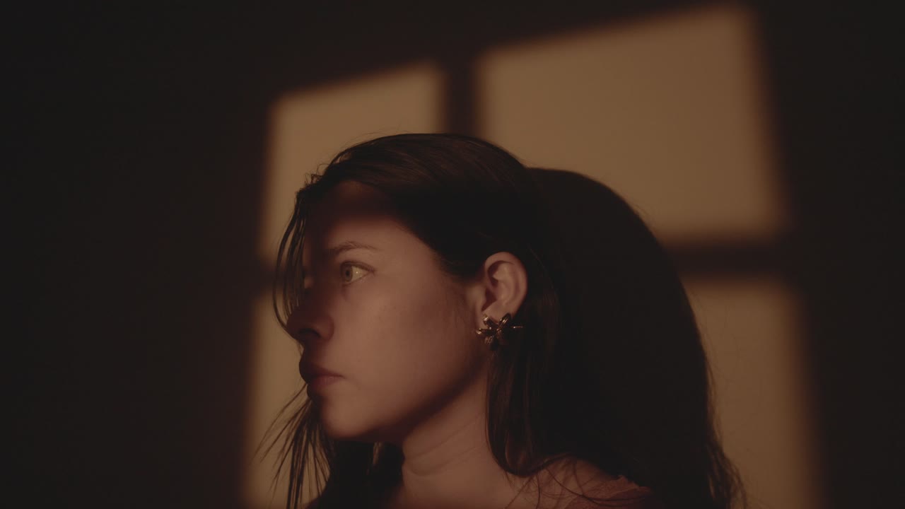 Thoughtful young woman in a calm interior setting, gazing into the distance