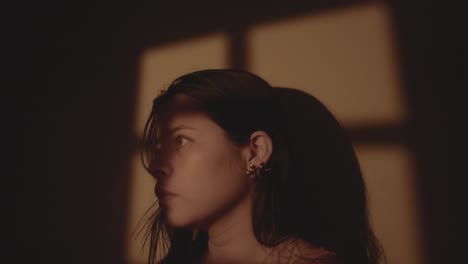 thoughtful young woman in a calm interior setting, gazing into the distance