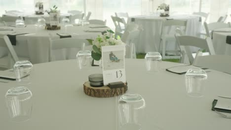 mesa de bodas con decoraciones rústicas y tarjeta de fecha bajo la tienda al aire libre