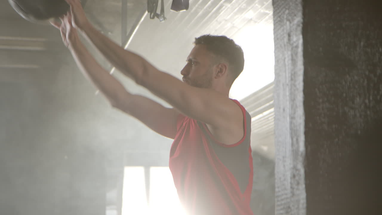 Man working out in a gym with a medicine ball