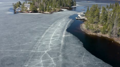 ice slowly receding from shoreline as the warm sunshine heats up the rocks and trees