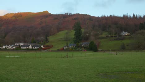 panorama of mountain, village, and green grassland at lake district, cumbria, england
