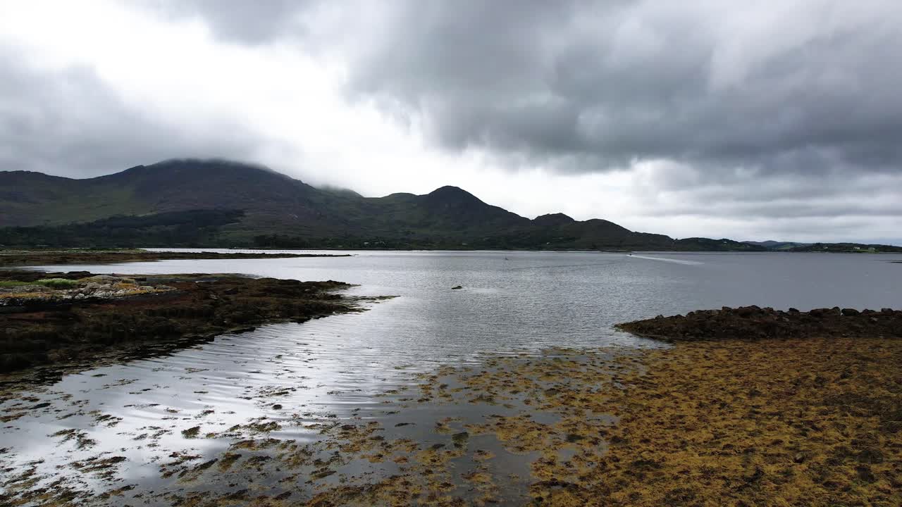 Una ripresa drone 4K in ascesa di Killmackogue Harbour con un motoscafo a Lauragh, Contea di Kerry, Irlanda