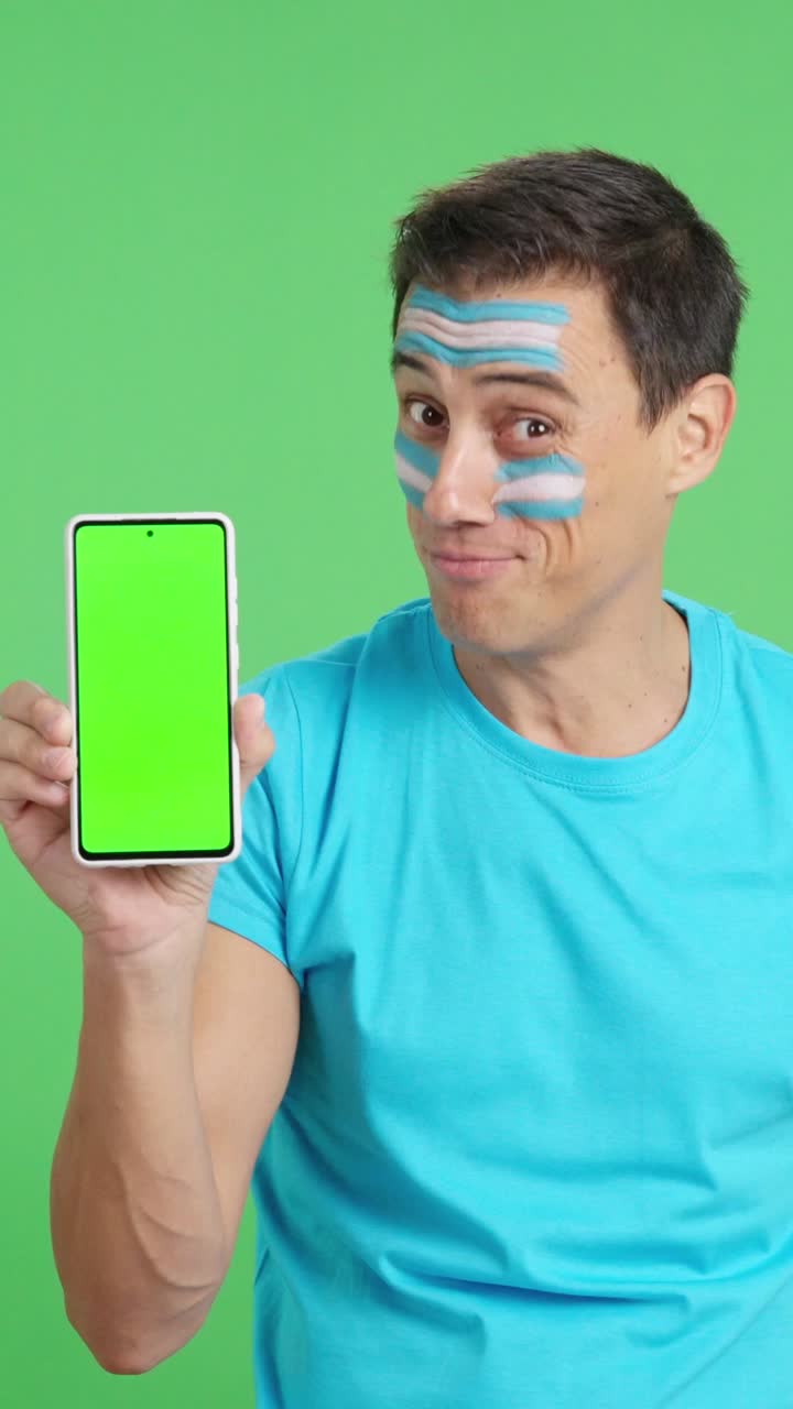 Argentina supporter looking at his mobile smiling and showing it