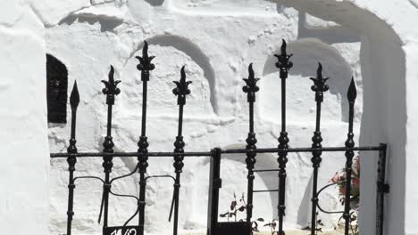 barras negras en la entrada de un cementerio andaluz blanco