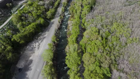 Aerial-track-of-bikers-along-river-near-Bridal-Veil-Falls-in-American-Fork-Canyon,-Utah-during-spring