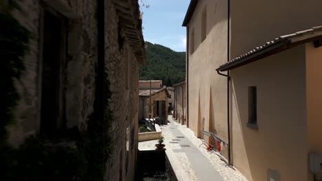 Vuelo-Aéreo-Entre-Una-Calle-Estrecha-E-Idílica-En-Rasiglia,-Un-Pequeño-Pueblo-Ubicado-En-La-Provincia-De-Perugia