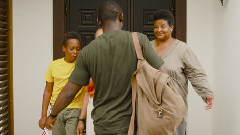 male soldier hugging and saying goodbye to his family outside home before going for military service