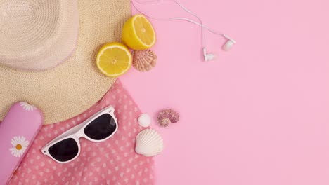 summer trendy beach accessories ordering on pastel pink background. stop motion flat lay