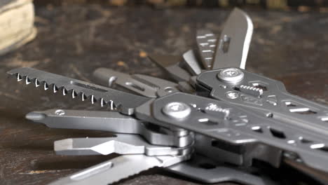 multifunctional knife tool on wooden surface, camera tilting upwards