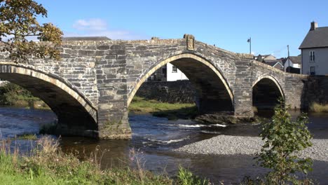 smooth zoom shot of an old bridge in a welsh town with a river flowing beneath