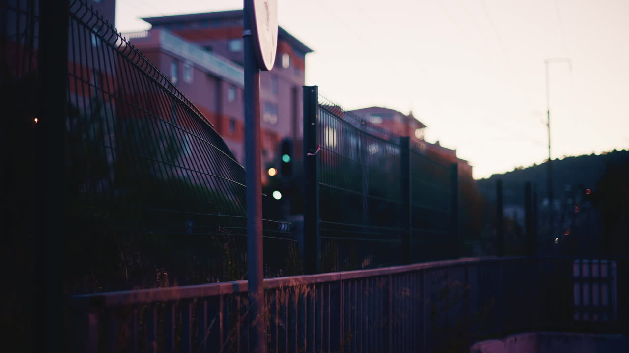 Train arrivant dans des conditions de faible luminosité au coucher du soleil, avec les phares illuminant la scène