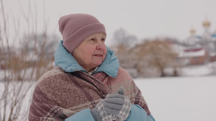 Donna anziana in un paesaggio invernale