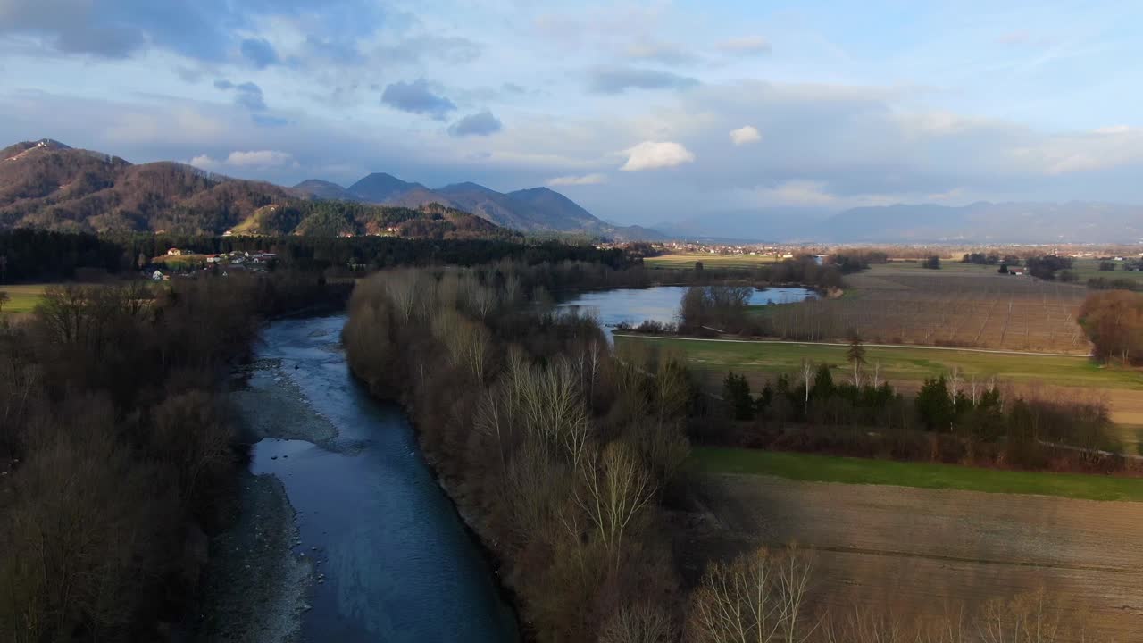 The Savinja River near Vrbje Slovenia at golden hour afternoon, Aerial flyover shot