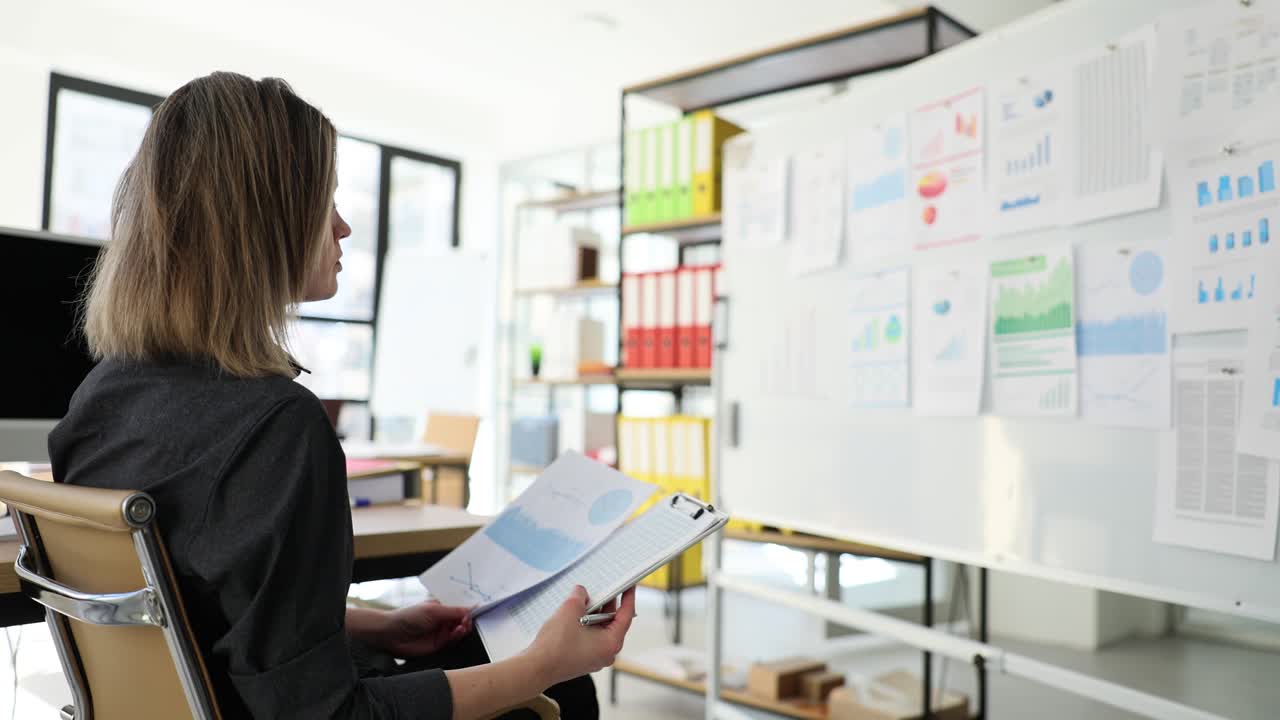 Woman analyzing data and charts in an office environment