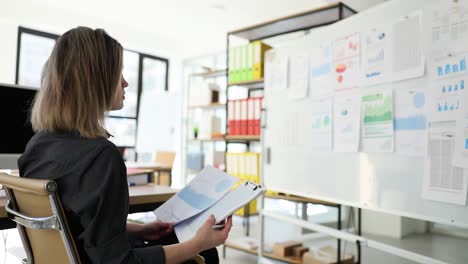 woman analyzing data and charts in an office environment