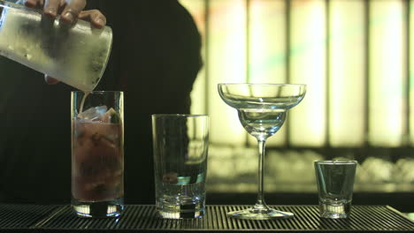 bartender pouring margarita and sprite in a glass