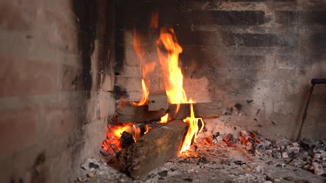 large wood blocks burning against the corner of old brick walls