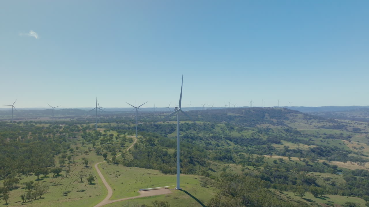múltiples turbinas eólicas girando en el viento en la cima de una colina en el campo australiano, dron 4k