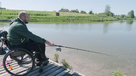 man with disabilities fishing at a lake. wheelchair. summertime. disabled person fishing