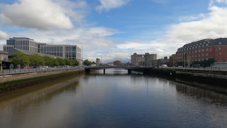 Vehicle-traffic-drives-on-bridge-over-wide-urban-canal-in-Ireland