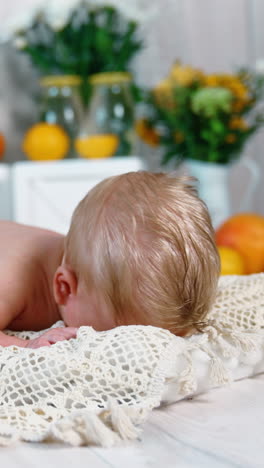 adorable blond caucasian newborn with blue eyes. little kid trying to hold up his head. studio footage. vertical video