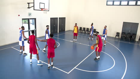 teams of multiracial male basketball players playing basketball in gym