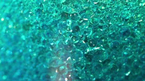 a detailed view of tiny, shimmering bubbles moving in a vibrant aqua liquid.
