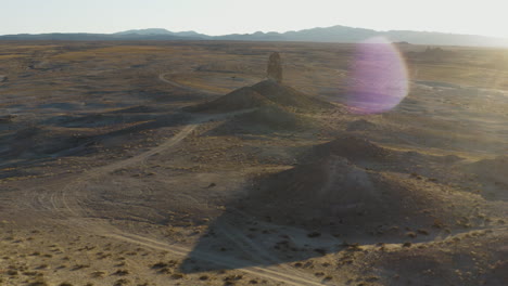 smooth revealing shot of an isolated pinnacle in the desert at golden hour