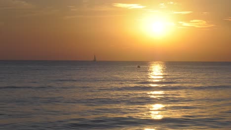 Sailing-Yacht-At-Sunrise-With-Sunlight-On-Calm-Sea