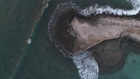overhead wedding couple walk out on to pier ocean drone shot