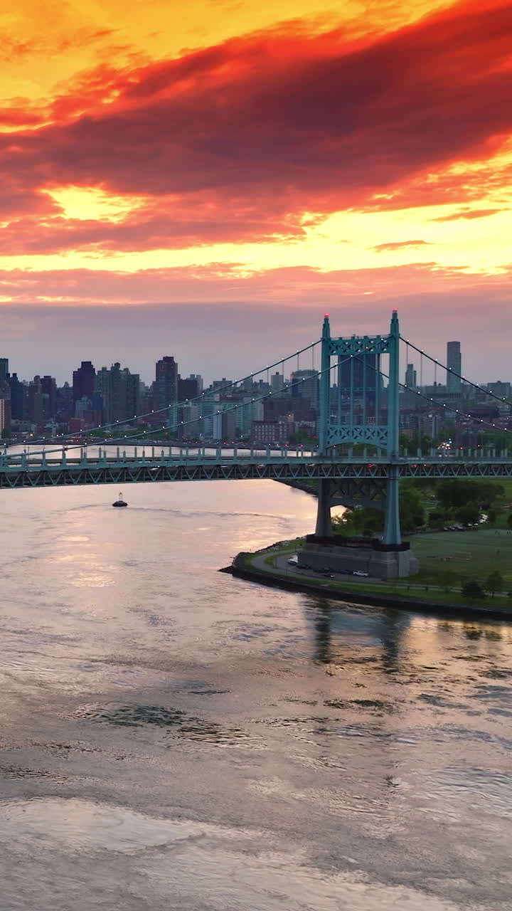 Amazing bright fire sky at sun dusk in New York. Robert F. Kennedy bridge against stunning city panorama. Vertical video