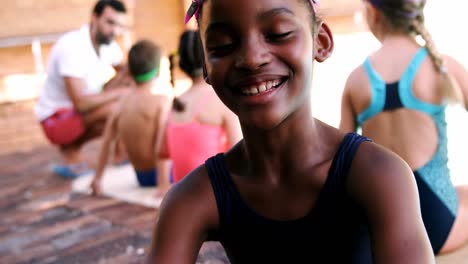 Niña-Sonriente-Sentada-Cerca-De-La-Piscina