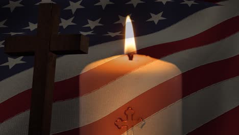 Animation-of-crucifix-and-candle-moving-over-american-flag