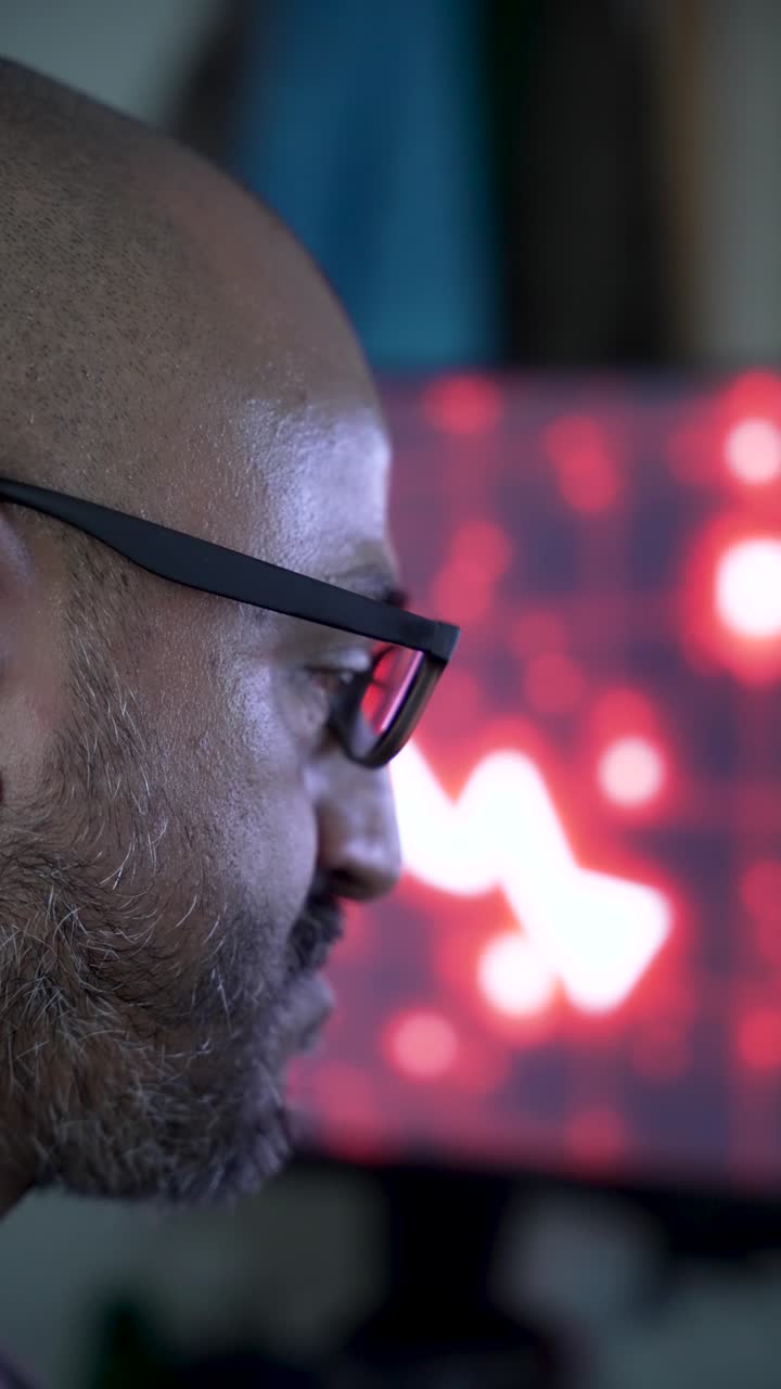 A person wearing glasses against a red background of stock market arrows. vertical video