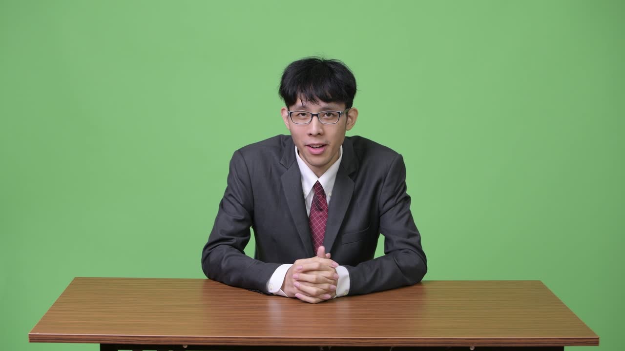 뉴스 캐스터 로서 카메라 와 대화 하는 젊은 아시아인 사업가