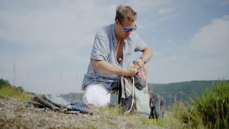 young man packing up his backpack to go for a hike, handheld crabbing shot
